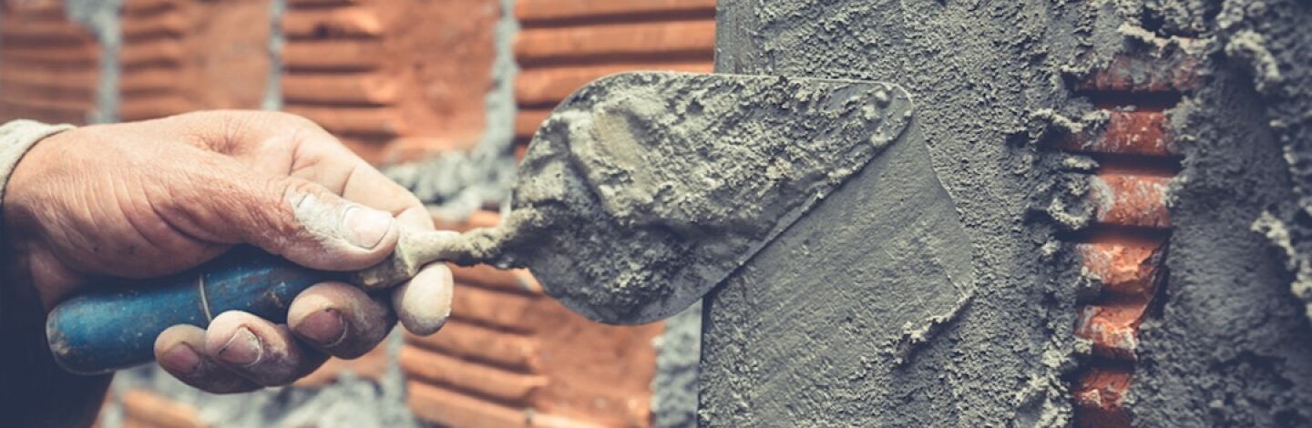 muratura muratore che costruisce un muro di mattoni